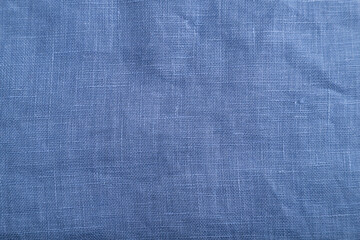 Fragment of smooth blue linen tissue. Top view, natural textile background.