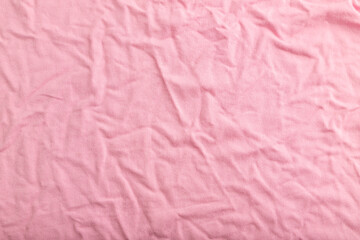 Fragment of pink cotton tissue. Top view, natural textile background.