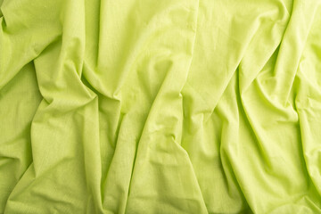 Fragment of green linen tissue. Top view, natural textile background.