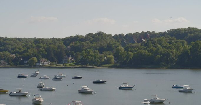 Aerial Pan of Boats Anchored on Harbor and Waterfront Houses Amongst Trees