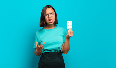 young hispanic woman looking angry, annoyed and frustrated screaming wtf or what’s wrong with you