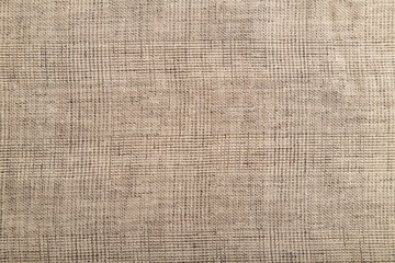 Fragment of smooth brown linen tissue. Top view, natural textile background.