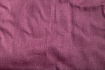 Fragment of smooth cotton purple tissue. Top view, natural textile background.