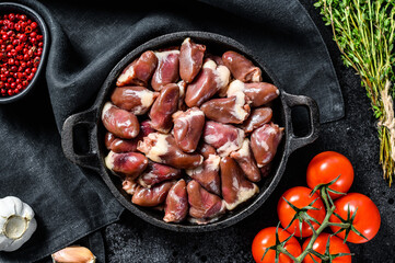 Fresh chicken hearts. Raw offal. Black background. Top view