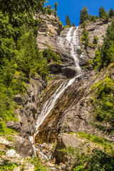 Fototapeta na wymiar Wasserfall an einem steilen Hang in der Bergen