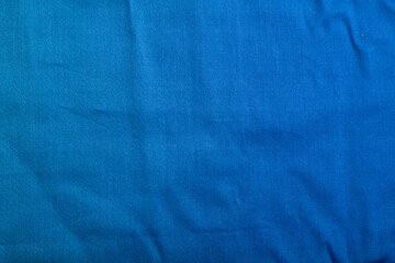 Fragment of smooth cotton blue tissue. Top view, natural textile background.