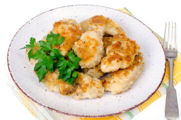 Breaded chicken fillet pieces on plate