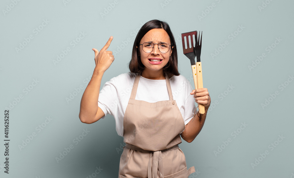 Canvas Prints young hispanic woman feeling confused and puzzled, showing you are insane, crazy or out of your mind