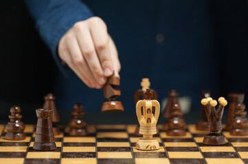 The hand of the young grandmaster makes a move on horseback against the rival king