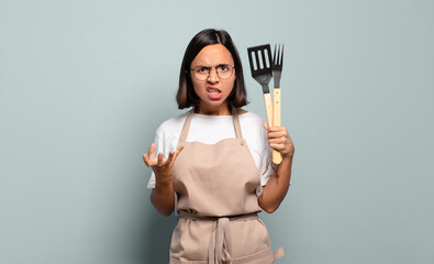 young hispanic woman looking angry, annoyed and frustrated screaming wtf or what’s wrong with you