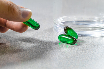 Agarrando medicamentos color verde de superficie con vaso de vidrio
