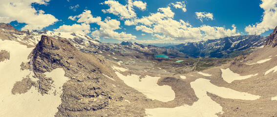 Fototapeta na wymiar Spectacular mountain panorama of late snow covering slopes.