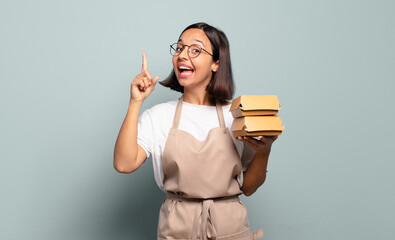 young hispanic woman feeling like a happy and excited genius after realizing an idea, cheerfully raising finger, eureka! © kues1