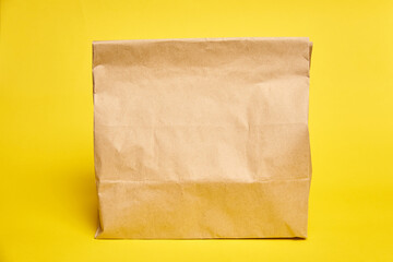 Paper bag lunch takeaway on yellow background