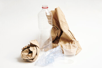 Crumpled paper bag, plastic bottle, polyethylene bag, plastic cup trash on white background