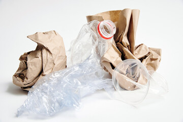 Crumpled paper bag, plastic bottle, polyethylene bag, plastic cup trash on white background.