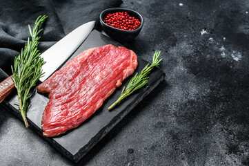 Flank steak. Raw Marble beef meat black Angus. Black background. Top view