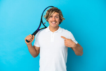 blonde tennis player man isolated on blue background with surprise facial expression