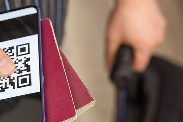 Obraz premium Travelers who have a passport and a phone with a Qr code indicating vaccination against Covid-19