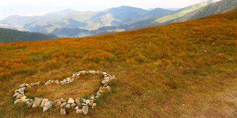 Landscape scenery. Stone heart on the meadow with view of the Low Tatras (Nizke Tatry) on the tourist path to the Chopok mountain peak. Summertime in the Northern Slovakia, Slovak Republic, Europe.
