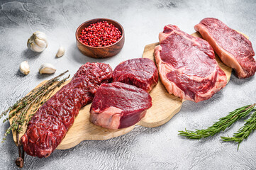 Variety of raw black angus beef meat steaks  fillet Mignon, rib eye or cowboy, Striploin or new york, skirt or machete. White background. Top view