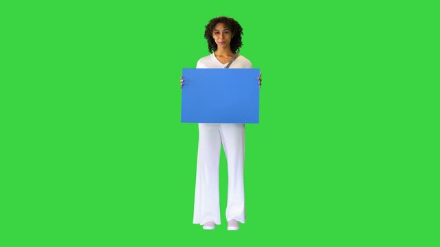 African American woman holding a blank blue sign on a Green Screen, Chroma Key.