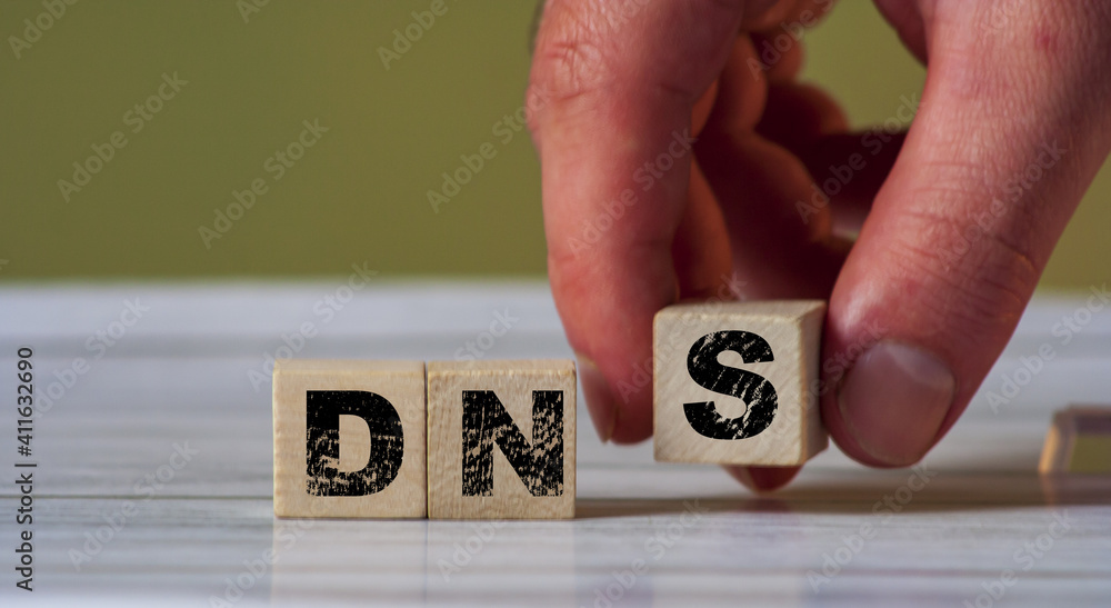 Poster dns concept of the domain name system on wooden cube background. network symbol