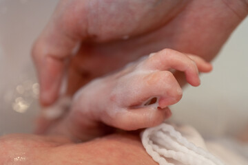 沐浴で新生児の手を洗う