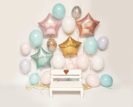 Photo zone on white background with colorful air gel balloons and wooden bench with heart for taking pictures of children, Birthday Part zone