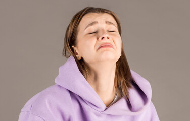 Portrait of desperate girl in sweater feeling sorry for mistake. indoor studio shot isolated on...