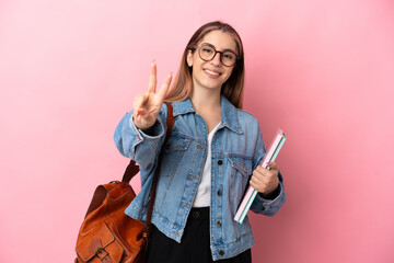 Young caucasian student woman isolated on pink background smiling and showing victory sign