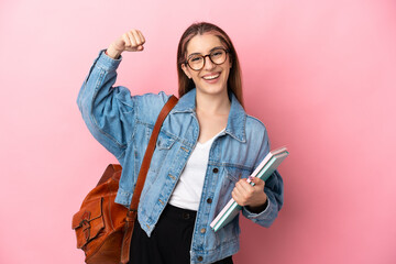 Young caucasian student woman isolated on pink background doing strong gesture
