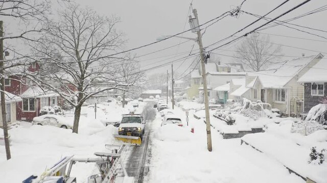 Snow plows clear residential street during snow storm