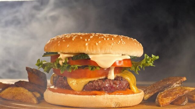 Smoke clouds envelop a tasty burger with crispy countrylike potato 
