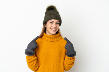 Young girl with winter hat isolated on white background giving a thumbs up gesture