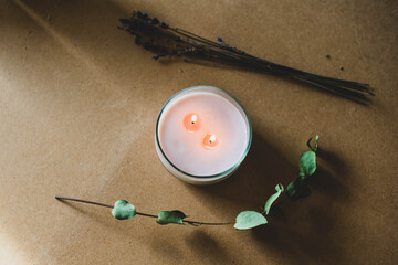 wooden wick candle. Handmade candle from paraffin and soy wax in glass with flowers and leaf on...