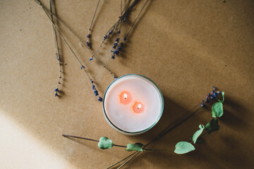 wooden wick candle. Handmade candle from paraffin and soy wax in glass with flowers and leaf on...