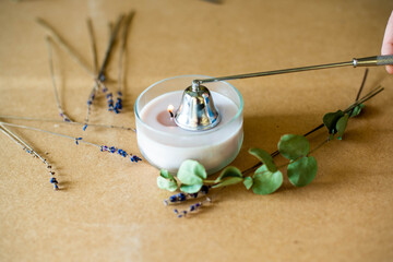Tools for making candles of white soy wax flakes, essential oil, wicks on pergament background....