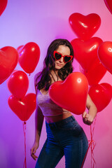 Valentine's Day. Young attractive woman holding a heart-shaped balloon in her hands.