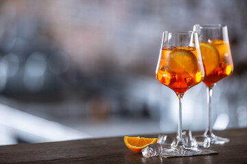 Typical summer sekt drink aperol spritz served in wine glass with aperol, prosecco, soda and a...