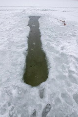 Hole in the ice on the lake. A bathing place for walruses.
