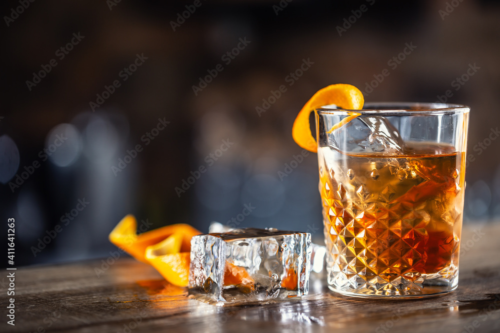 Wall mural Old fashioned rum drink on ice with orange zest garnish