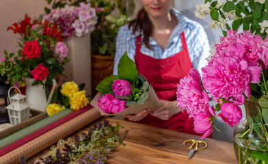 Crop view saller of flowers. Floristic business. Arrangement of bouquets.