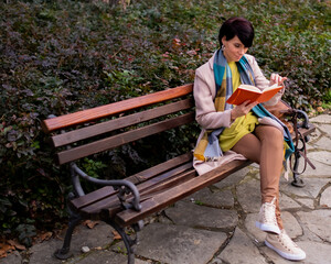 Woman in multicolored clothes reading a book
