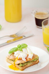 Breakfast with a sandwich with poached egg and avocado