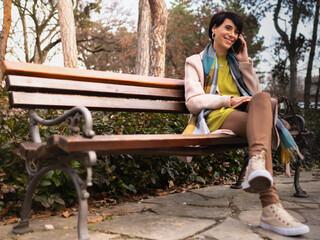 woman sitting at the park and using phone