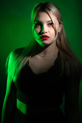 Fototapeta premium portrait of a blonde girl with bright makeup in green light