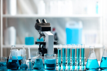 Chemistry laboratory glassware, science laboratory research and development concept, flask, beaker, and test tubes with blue liquid water sample test, scientific test tubes equipment
