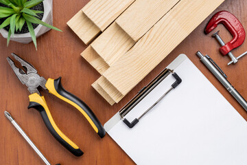 carpenter planning work concept. above view. blank clipboard, wooden planks and tools on table....