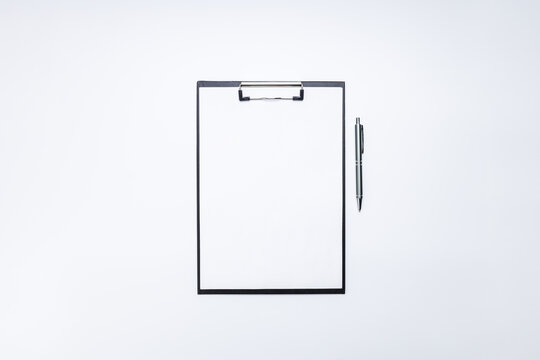 blank clipboard mockup for goals or aspirations at white desk. above view. template for checklist or questionnaire